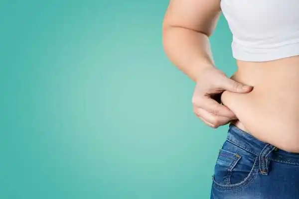 Image of woman pinching her love handles to show weight gain Coatbridge